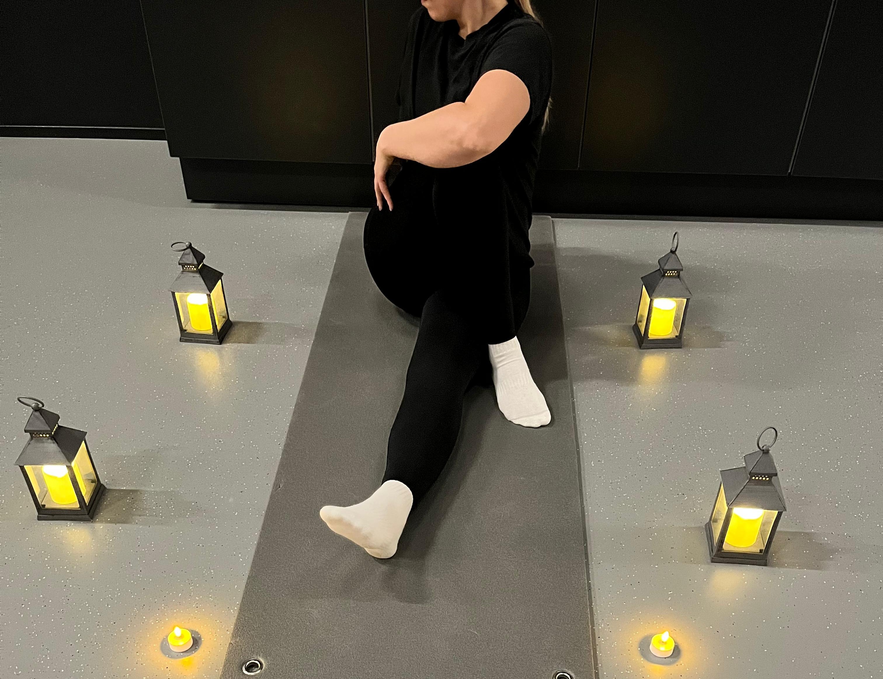 liikunnanohjaaja tunnelmavalossa istumassa lattialla