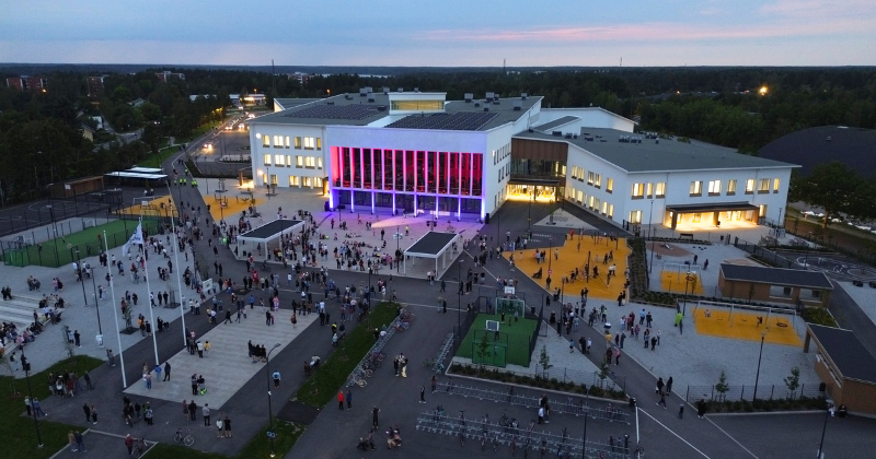 Ilmakuva Wintterin edestä, runsaasti ihmisiä pihalla ihailemassa seinään heijastettua valotaideteosta.