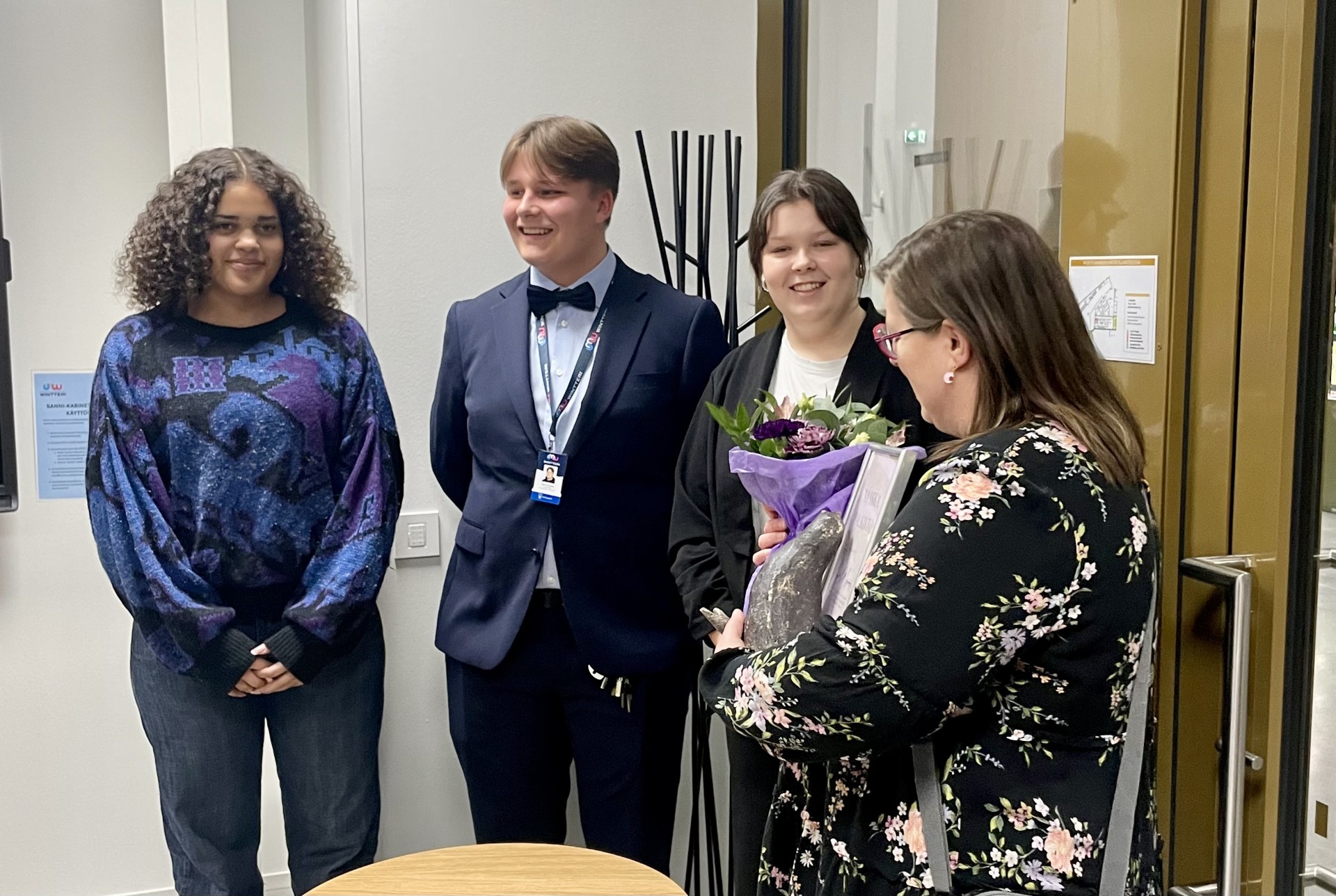 kolme nuorta onnittelee naakka kiertopalkinnon saanutta naista