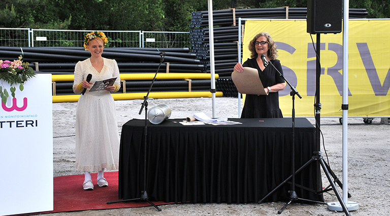 Sivistyspalveluiden erityisasiantuntija Inkeri Parviainen juontaa tapahtuman kulkua. Taustalla kirjailija Heli Laaksonen kääntää Parviaisen lukemaa peruskirjatekstiä lounaismurteelle. 