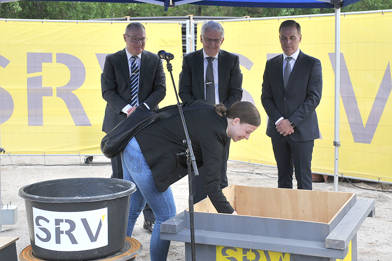 Opetusministeri Li Andersson muuraamassa peruskiveä. 