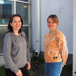 Palvelusihteeri Outi Soininen ja liikuntapalvelujen Taru Joutsa-Huutola hymyilevät ja katsovat kohti.