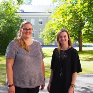 Jenni Leppänen ja Annina Kiiveri katsovat hymyillen kameraan, taustalla kesäinen maisema.