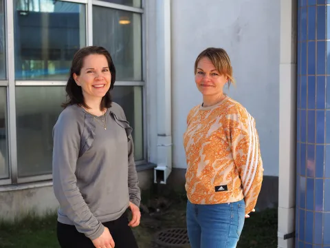 Palvelusihteeri Outi Soininen ja liikuntapalvelujen Taru Joutsa-Huutola hymyilevät ja katsovat kohti.