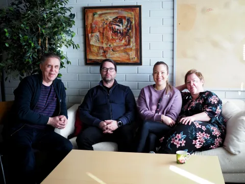 Yhtenäiskoulun rehtori Jukka Silvola, matematiikan ja tietotekniikan opettaja Petri Puukki, vararehtori Erika Lehtonen ja kotitalousopettaja Lotta Koisti istuvat sohvalla.